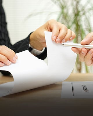 One person tearing paper, the other holding a pen - Big Catch Consulting