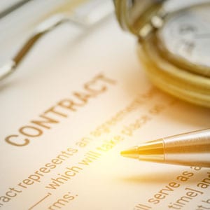 Signing a contract with a pen, a clock on top of the paper - Big Catch Consulting