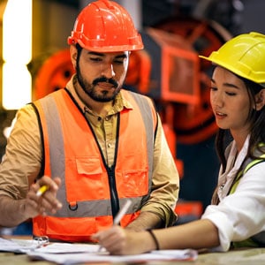 Two workers collaborating on a construction project - Big Catch Consulting